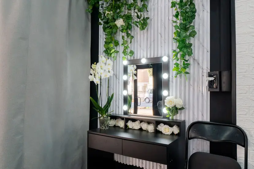Postazione trucco con specchio a luci e fiori bianchi