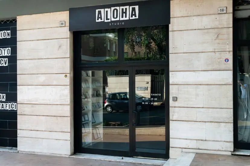 Ingresso di Aloha Studio con insegna nera e porte a vetri