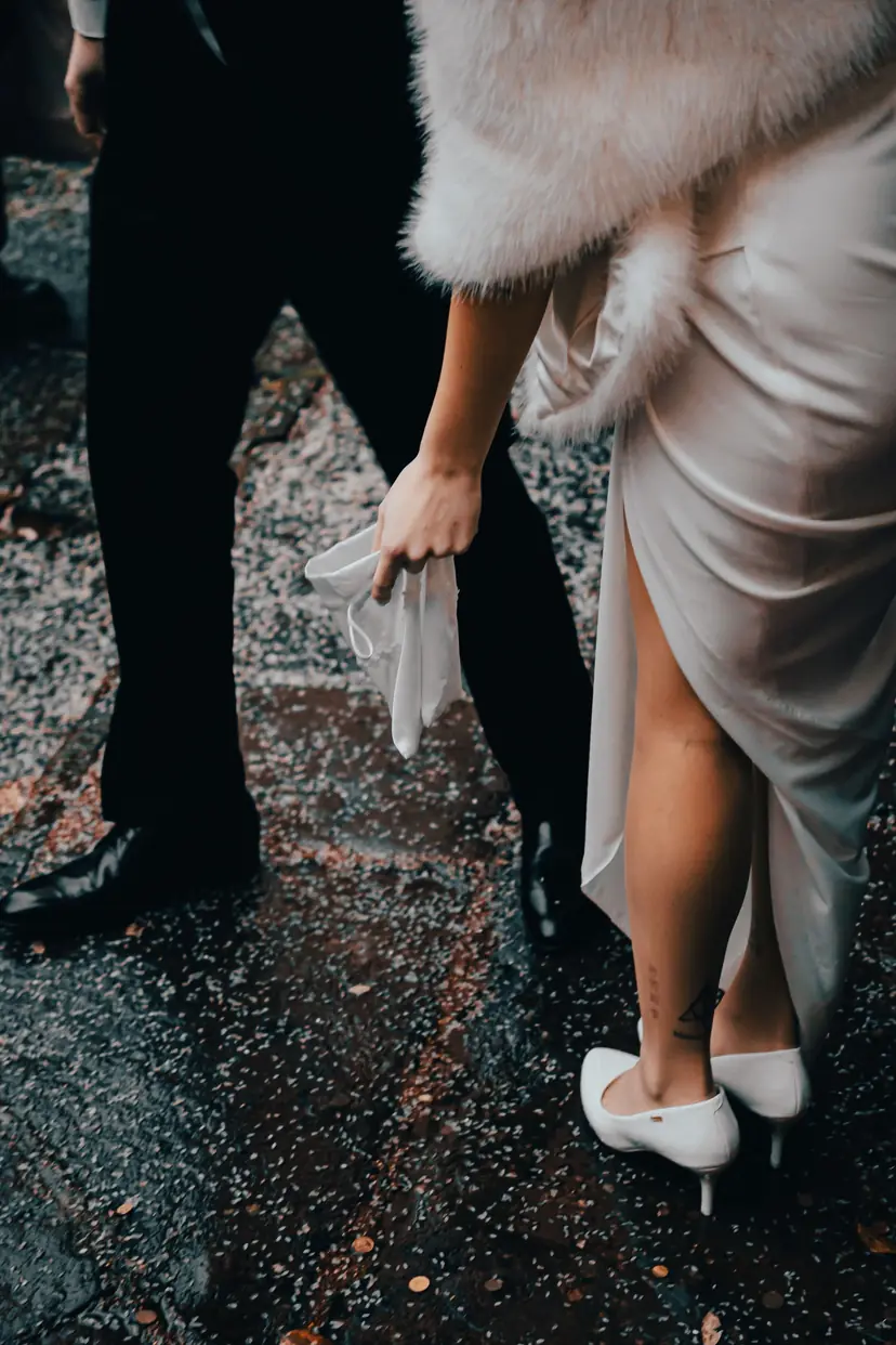 Sposa con stola in pelliccia e velo accanto allo sposo