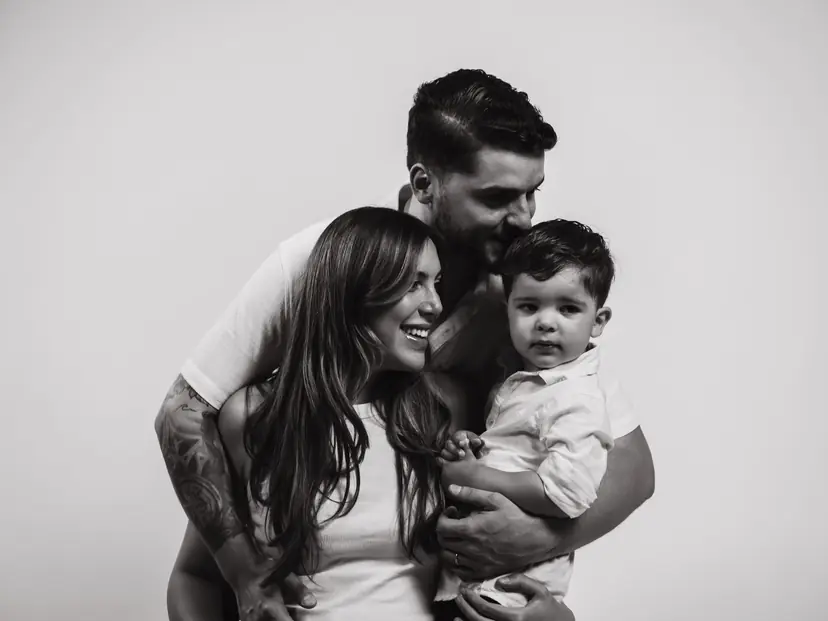 Ritratto di famiglia in bianco e nero: genitori sorridenti con il loro bambino
